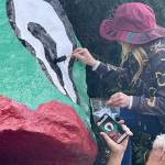 Denise Stoughton assists in repainting Frog Rock to its original visage  droopy pupil and all.