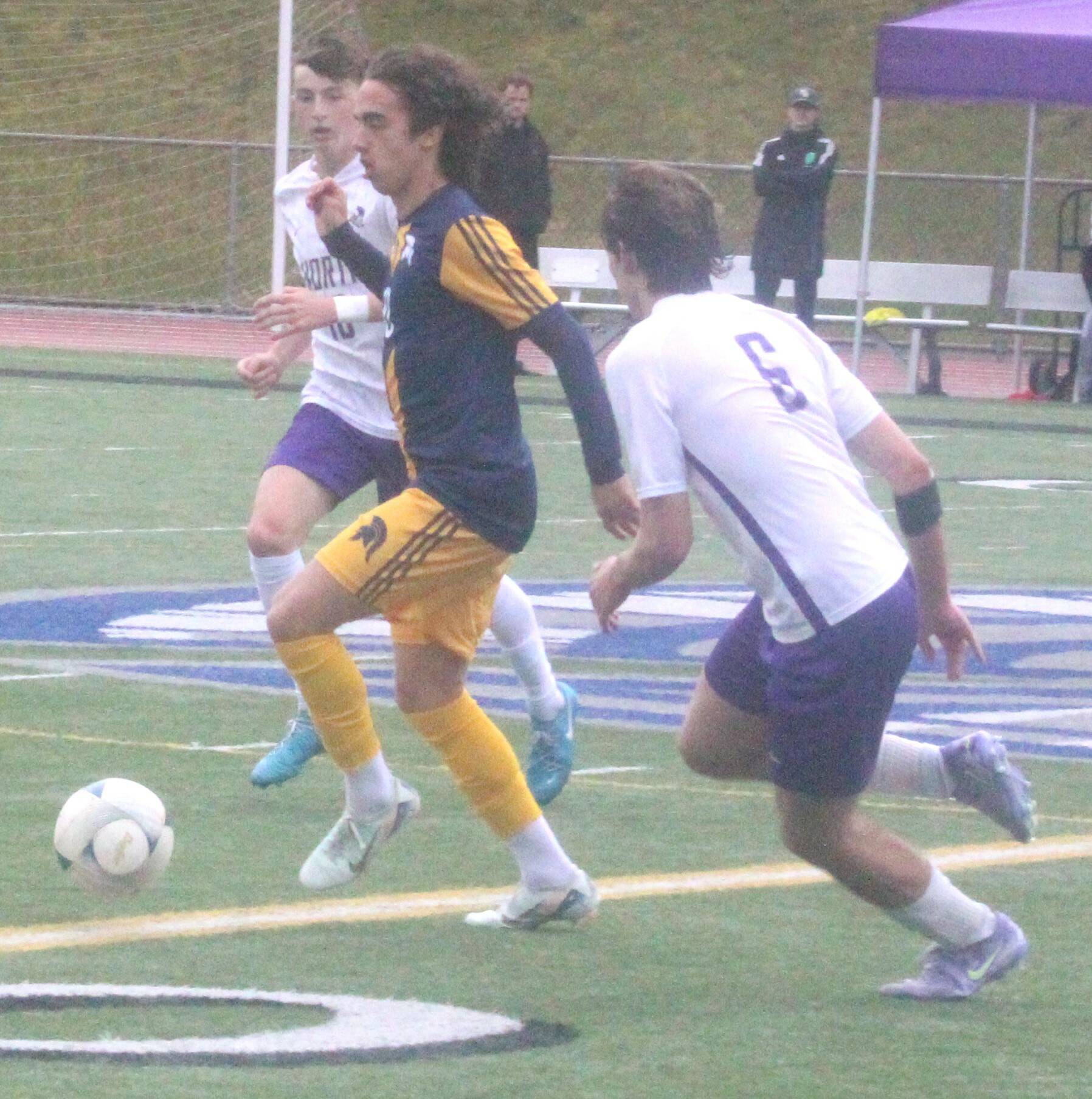 Spartan Blake Moyer dribbles the ball past defenders in a Bainbridge district championship win over North Kitsap May 17 at Olympic High School.
