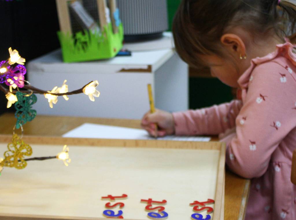 Student Sōley McCuistion practices writing and spelling on a worksheet.