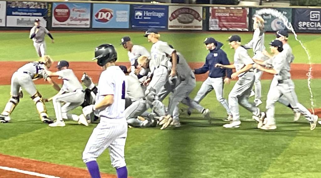 Spartan players celebrate in style following their state championship win while an Anacortes player looks on.