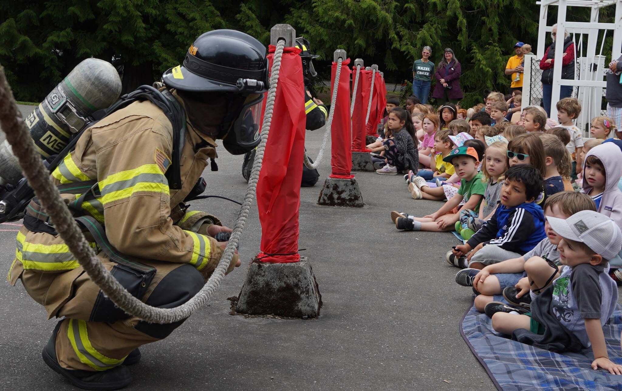 Joshua Kornfeld/Kitsap News Group
BI firefighter Kiel Reijnen shows students firefighting protective equipment.