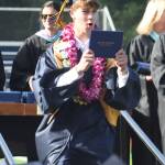 Parker Kruglik holds out his diploma to celebrate during graduation.