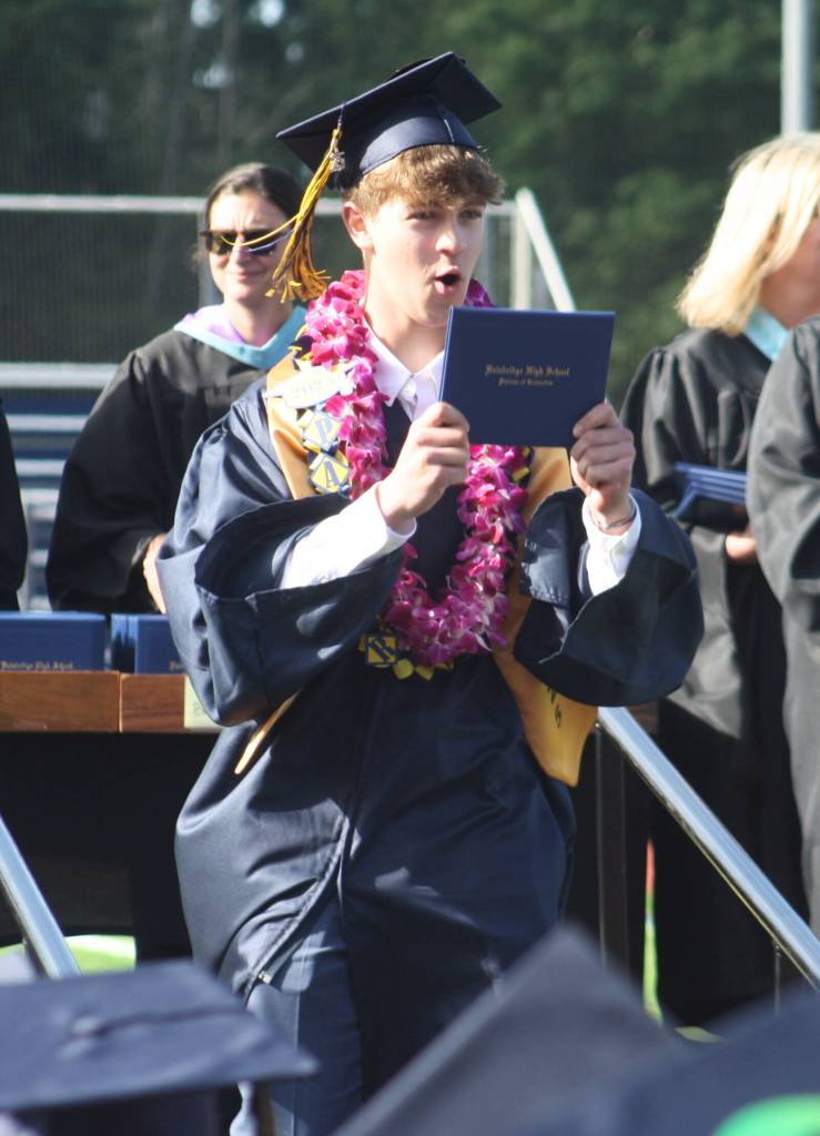 Parker Kruglik holds out his diploma to celebrate during graduation.