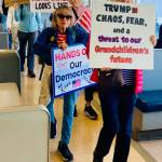 Protesters carry homemade signs against the Trump administration aboard the ferry June 14.