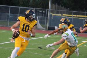 Luke Caputo/Kitsap News Group photos
Spartan QB Nate Putman rolls out with a defender in pursuit during a 45-6 Bainbridge loss to Tumwater Sept. 12.