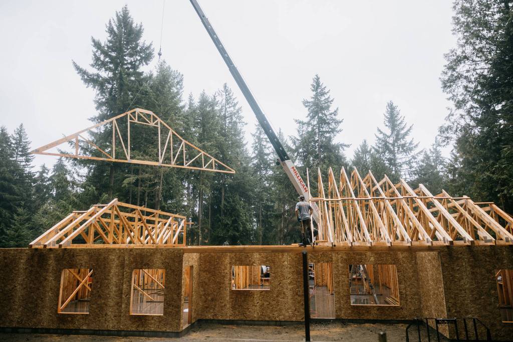 KFM Construction courtesy photo
Derek Moore, co-owner of KFM Construction and a veteran, moves a beam on the roof of Bomkes soon-to-be home.