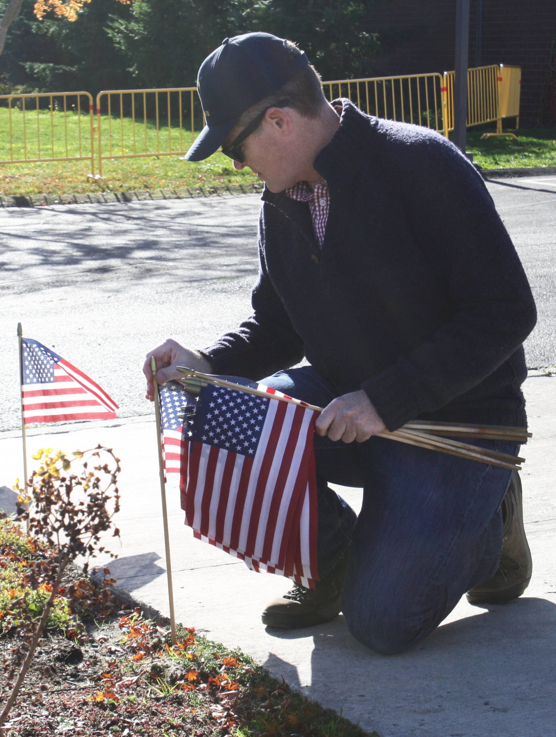 Michael Yund, who served in the U.S. Armys Air Defense Artillery for 27 years, plants a flag at the Veterans Memorial at Bainbridge High School in honor of servicemembers from BI who passed away in combat.