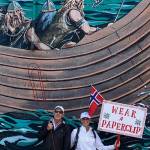 The Pedersens pose with their paperclip gear in front of the Viking mural in downtown Poulsbo during a rally in April.