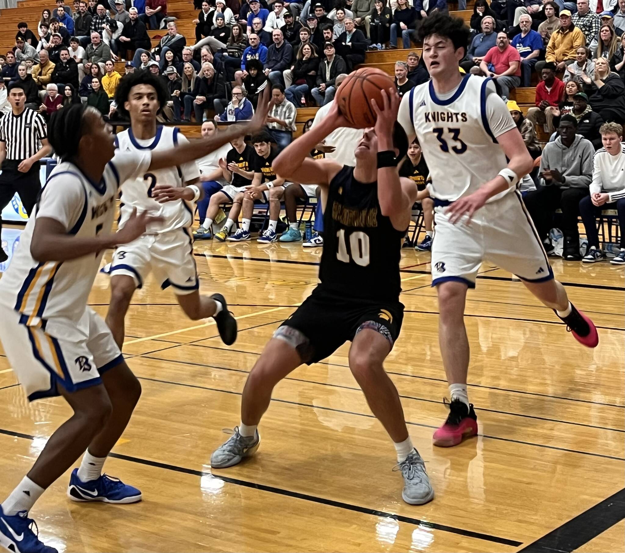 Spartan Ryan Rohrbacher attempts to get a shot off with Knights Junior Davis-McWhorter, Aaron Matthews, and Jay Beahan closing in during a 71-42 Bremerton home win over Bainbridge Dec. 16.