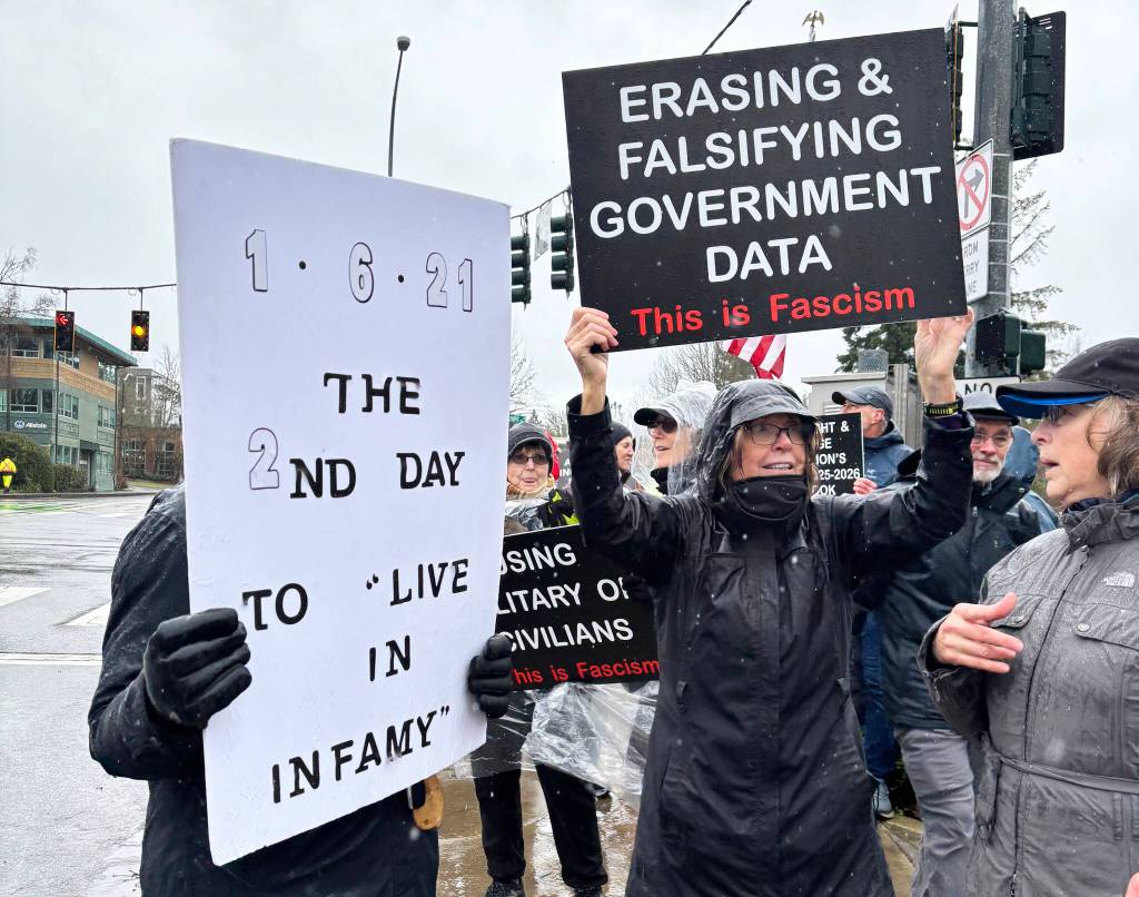 Molly Hetherwick/Kitsap News Group photos
Protesters held waterproof signs to battle the weather at the corner of Highway 305 and Winslow Way Jan. 6.