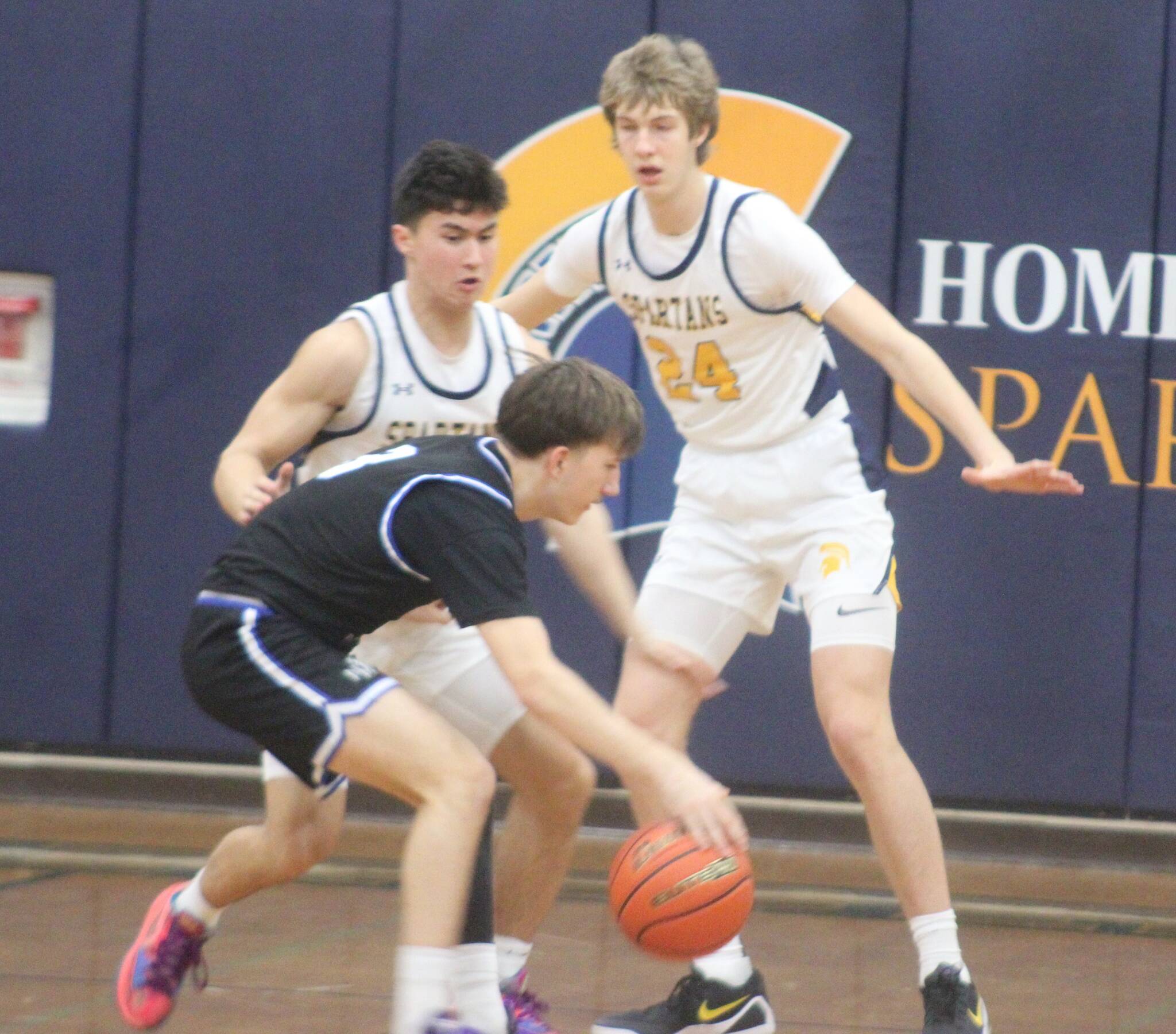 Spartans Haden Fink and Kethan Reed surround a North Mason Bulldog in a 76-52 senior night win over North Mason Feb. 3 at Bainbridge High School.