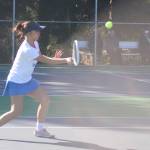 Trojan Viola Abogado hits a volley during her singles match against Bainbridge March 30.